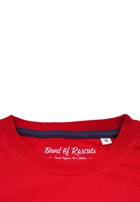 Rød t-shirt i bomuld med rund halsudskæring og kontrasterende marineblåt bånd. Viser "Band of Rascals" branding langs kraven.