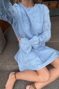 Svetlo modra obleka z rožnatim vezenjem, dolge napihnjene rukave in lokom na manšeti. Ohlapen krilo z teksturirano blago.