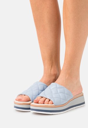 Light blue quilted slide sandals with an open toe, featuring a thick white sole and layered beige and gray accents.