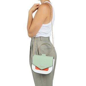 Femme portant un pantalon taille haute gris clair et un haut blanc sans manches, portant un sac bandoulière bicolore avec chaîne dorée et poignée ronde.