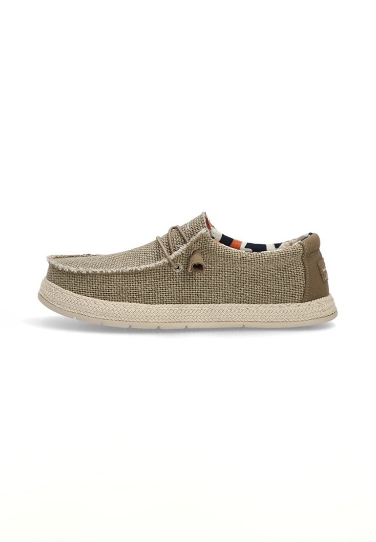 Zapato de lona texturizada en beige con un tira en el talón de color marrón claro, detalle de cordones y suela trenzada de un beige claro. El interior presenta un forro con un patrón en contraste.