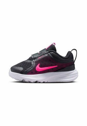 Zapatilla deportiva negra y rosa con parte superior de malla, tobillo acolchado, banda elástica y suela blanca. Presenta un prominente logo de Nike en rosa y detalles texturizados.