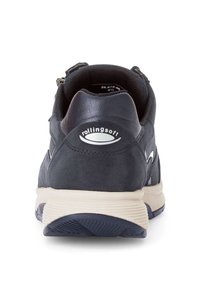 Chaussure de sport bleu foncé, tige en cuir texturé, talon rembourré, semelle intermédiaire crème, avec le logo "rollingsoft" et des accents de design.