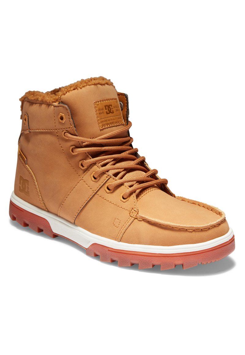 Tansfarbene Lederstiefel mit einem Kunstfellkragen, runder Spitze, schnürbarem Design und einer weißen Zwischensohle sowie einer strukturierten, orangen Gummisohle.