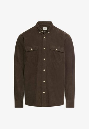 Chemise en velours côtelé brun avec un col boutonné, deux poches poitrine et des boutons blancs. Manches longues avec des poignets boutonnés.