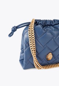 Bolso de mano de cuero acolchado azul con una cadena dorada y un cierre decorativo. Presenta un borde fruncido en la parte superior y una superficie suave y texturizada.