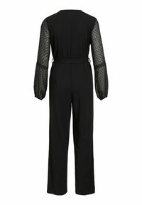 Črn kombinezon s dolgimi prozornimi rokavi v obliki puf, okrašenimi s pikami, prilegajočim pasom in širokimi ravnimi hlačami. Zadaj prikazuje preprost dizajn.