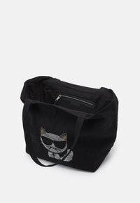 Černá plátěná taška s hravým designem kočky se slunečními brýlemi, lesklým kamínkovým detailem a zipovou vnitřní kapsou.