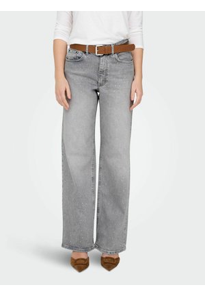 Jean gris à taille large avec une texture mouchetée, assorti à une ceinture en cuir marron et des ballerines marron à bout pointu. Tissu en denim doux, design décontracté.