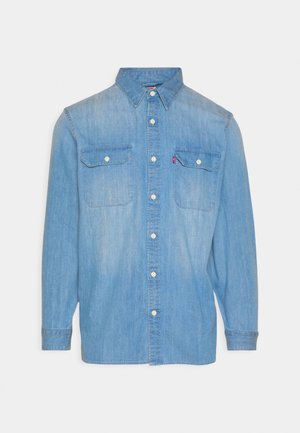 Lichtblauw denim overhemd met lange mouwen, knoopsluiting aan de voorkant, twee borstzakken met knopen en een spitse kraag, plat uitgestald op een witte achtergrond.