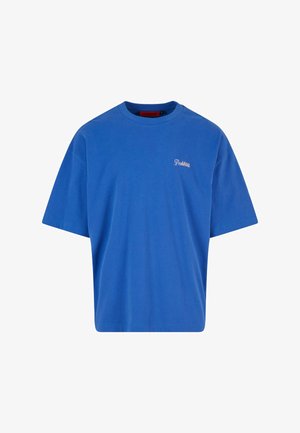 Sinine puuvillane T-särk, lõdva istuvusega, lühikeste varrukate ja väikese roosa logoga vasakul rinnal. Ei ole mustreid ega täiendavaid aksessuaare.