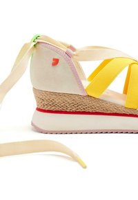Sandalia cuña con tiras elásticas amarillas, acentos de ante rosa, una suela intermedia de yute trenzado y una suela de goma roja. Incluye cordones largos beige.