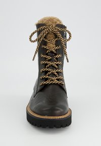 Botín de cuero marrón que cuenta con un forro de piel sintética, gruesos cordones marrones y beige, una suela gruesa y un detalle de cremallera lateral.