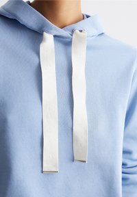 Felpa con cappuccio di colore azzurro chiaro, realizzata in tessuto morbido, con un cordino e un marchio bianco. Design con cappuccio, vestibilità rilassata e texture liscia.
