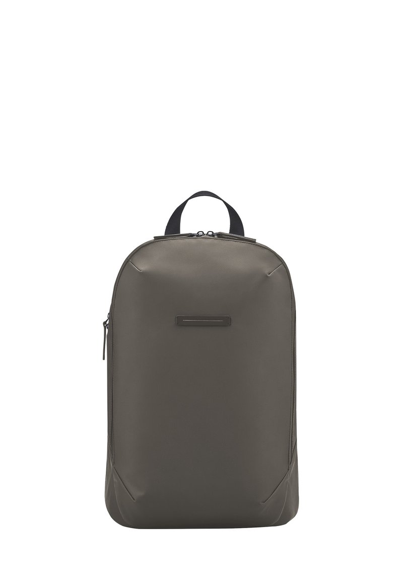 Sac à dos gris foncé en matériau lisse et durable. Dispose d'une poignée supérieure et d'un compartiment principal zippé, avec des accents subtils et un design minimaliste.