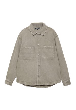 Stor lysebrun skjorte med knapper, to brystlommer og klassisk krave, lange ærmer og en let buet kant.