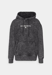 Felpa con cappuccio in un tessuto grigio scuro texturizzato. Presenta una tasca frontale e il logo "Tommy Jeans". Cordini regolabili sul cappuccio.