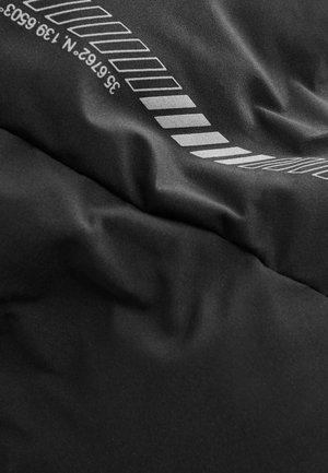 Tissu noir à texture lisse, présentant des lignes graphiques et des chiffres blancs, créant un design superposé avec des largeurs de ligne variées.
