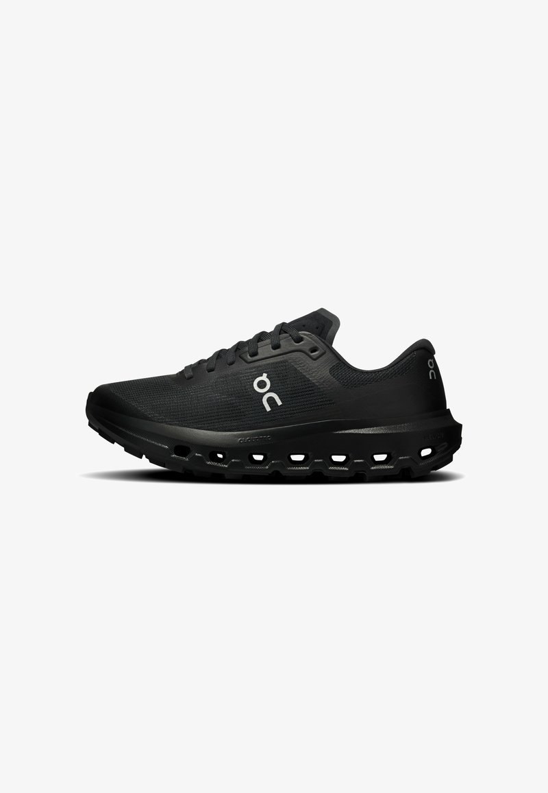Chaussure de course athlétique noire avec semelle coussinée présentant des trous hexagonaux et logo blanc "oc" sur le côté et la collerette du talon.