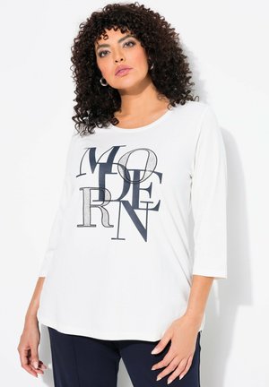 T-shirt blanc à manches longues avec un imprimé graphique moderne en bleu marine. Col rond et coupe décontractée avec une texture subtile.