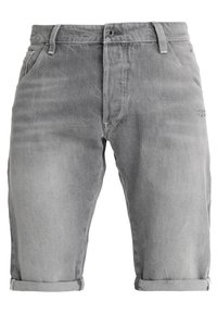 Pantalones cortos de mezclilla gris hasta la rodilla con dobladillos enrollados, botón y cremallera en el frente, pasadores para cinturón y bolsillos laterales.