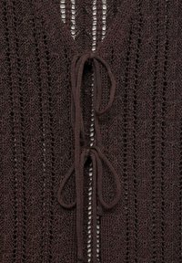 Cardigan tricotat maro, cu modele verticale din dantelă, de tip V la gât și două legături în față. Material texturat, ușor, cu un design deschis.