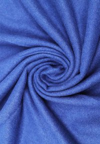 Tessuto blu disposto a spirale, con una consistenza morbida e liscia, un delicato lucido e una distribuzione uniforme del colore.