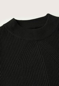 Col roulé en tricot noir côtelé avec un large col rond et un détaillé en motif côtelé diagonal sous le col.