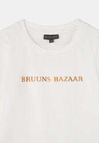 T-shirt de algodão branca com decote redondo, apresentando texto bordado laranja "BRUUNS BAZAAR" ao centro. Detalhe de costura delicada no colarinho.