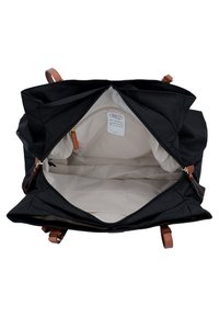 Borsa nera in tela con dettagli in pelle marrone; l'interno spazioso presenta foderatura beige, chiusura con zip e più scomparti per un'organizzazione ottimale.