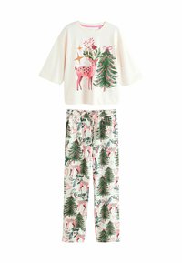 Bawełniany zestaw piżamowy składa się z kremowej bluzki z krótkim rękawem z nadrukiem jelenia i drzew, oraz spodni w wzory z reniferami i sosnami w delikatnych kolorach.
