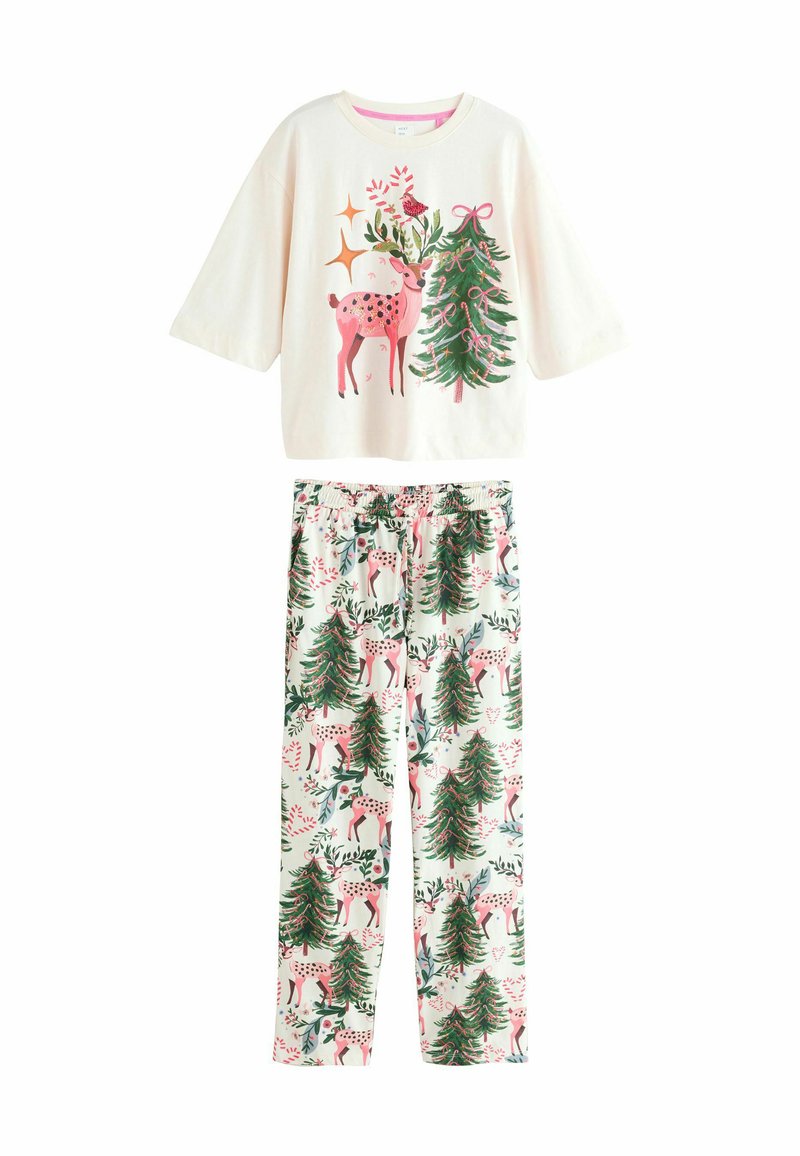 Bawełniany zestaw piżamowy składa się z kremowej bluzki z krótkim rękawem z nadrukiem jelenia i drzew, oraz spodni w wzory z reniferami i sosnami w delikatnych kolorach.