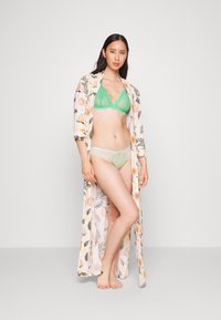 Robe com padrão floral em rosa claro, bralette de renda verde menta e panties com detalhes em renda coincidindo. Textura suave, design de frente aberta.