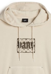 Crème-kleurige hoodie met een groot zwart grafisch logo, een trekkoordkap en een kangoeroezak; gemaakt van zachte, gestructureerde stof.