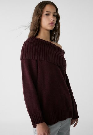 Burgundy sweater with an off-shoulder design, ribbed neckline, and wide sleeves. Made from textured knit material.