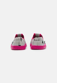 Pelēki un balti svītraini slip-on apavi ar rozā pūkainu zoli un aizmuguri. Apaļš dizains ar mīkstu, teksturētu apdari un bez redzamiem stiprinājumiem.