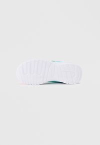 Podešev boty s texturovanou bílou gumovou spodní částí, obsahující diagonální drážky; akcenty v tyrkysové barvě poblíž paty.