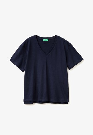 Granatowy T-shirt z krótkim rękawem, dekoltem w serek, luźnym krojem oraz zieloną metką wewnątrz kołnierza.