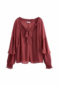 Blouse à manches longues couleur rouille avec poignets volantés, manches cloche à étages, encolure froncée et détail noué sur le devant.