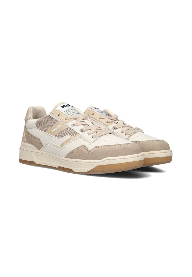 Beige sneakers with a suede and mesh upper, white accents, perforated toe, and a rubber outsole. Features flat laces and stitched details.