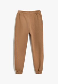 Bruine sweatpants van zachte stof, met een elastische tailleband en taps toelopende boorden, ontworpen voor comfort en bewegingsvrijheid.