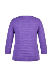 Lila Langarmshirt mit einem strukturierten, wellenförmigen Muster im gesamten Stoff; weiches Material mit einer lockeren Passform.