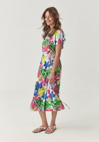 Bloemenpatroon jurk met korte mouwen, in levendige kleuren zoals roze, blauw en groen. Strikken in de taille, enkel-lange zoom.