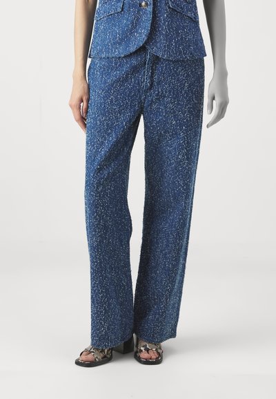 Blue textured wide-leg pants featuring a speckled pattern, with a relaxed fit and a drawstring waistband. Paired with black sandals.