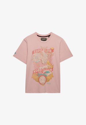 T-shirt rosa chiaro con grafica che raffigura una gru, onde, teste di tigre, piante e testo "SUPERIOR KOBE JAPAN" sul davanti.
