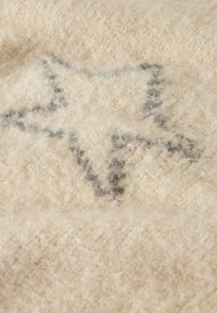 Vlněná deka v krémové barvě s měkkým, strukturovaným povrchem, který nese jemný, tmavošedý vzor hvězd. Světlý a příjemný vzhled.