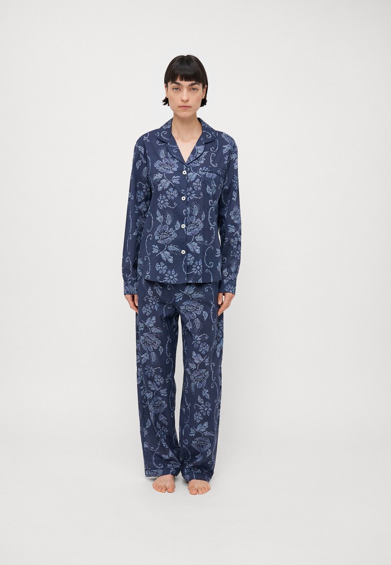 Navy pajama set with floral pattern, featuring a button-up shirt and loose-fitting pants in soft fabric. Includes long sleeves and a collar.