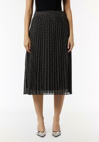 Czarna spódnica plisowana z wzorzystym wzorem i textured wykończeniem. Posiada dopasowany pas i sięga poniżej kolan. Noszona z srebrnymi szpilkami.