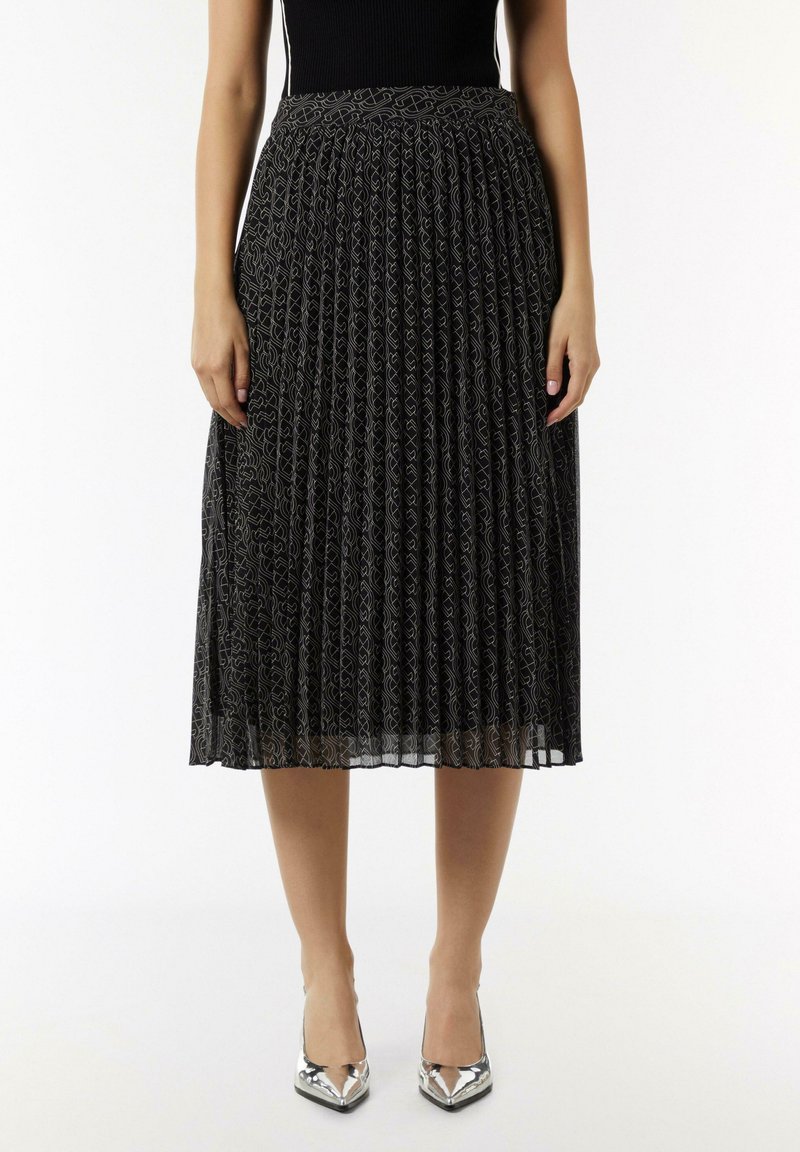 Czarna spódnica plisowana z wzorzystym wzorem i textured wykończeniem. Posiada dopasowany pas i sięga poniżej kolan. Noszona z srebrnymi szpilkami.
