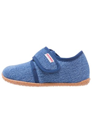 Chausson en tissu texturé bleu avec une sangle en velcro, semelle en caoutchouc brun clair, et forme arrondie, adapté à une utilisation intérieure.